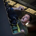 Royal Australian Air Force technicians conduct maintenance operations inside an aircraft hangar. (Photo: Australian Department of Defence)