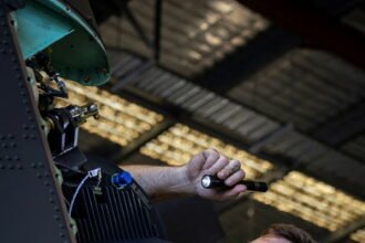 Royal Australian Air Force technicians conduct maintenance operations inside an aircraft hangar. (Photo: Australian Department of Defence)