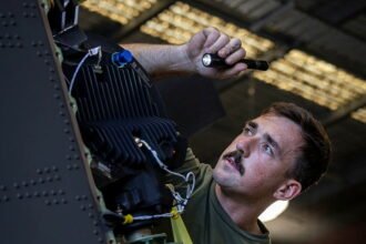 Royal Australian Air Force technicians conduct maintenance operations inside an aircraft hangar. (Photo: Australian Department of Defence)